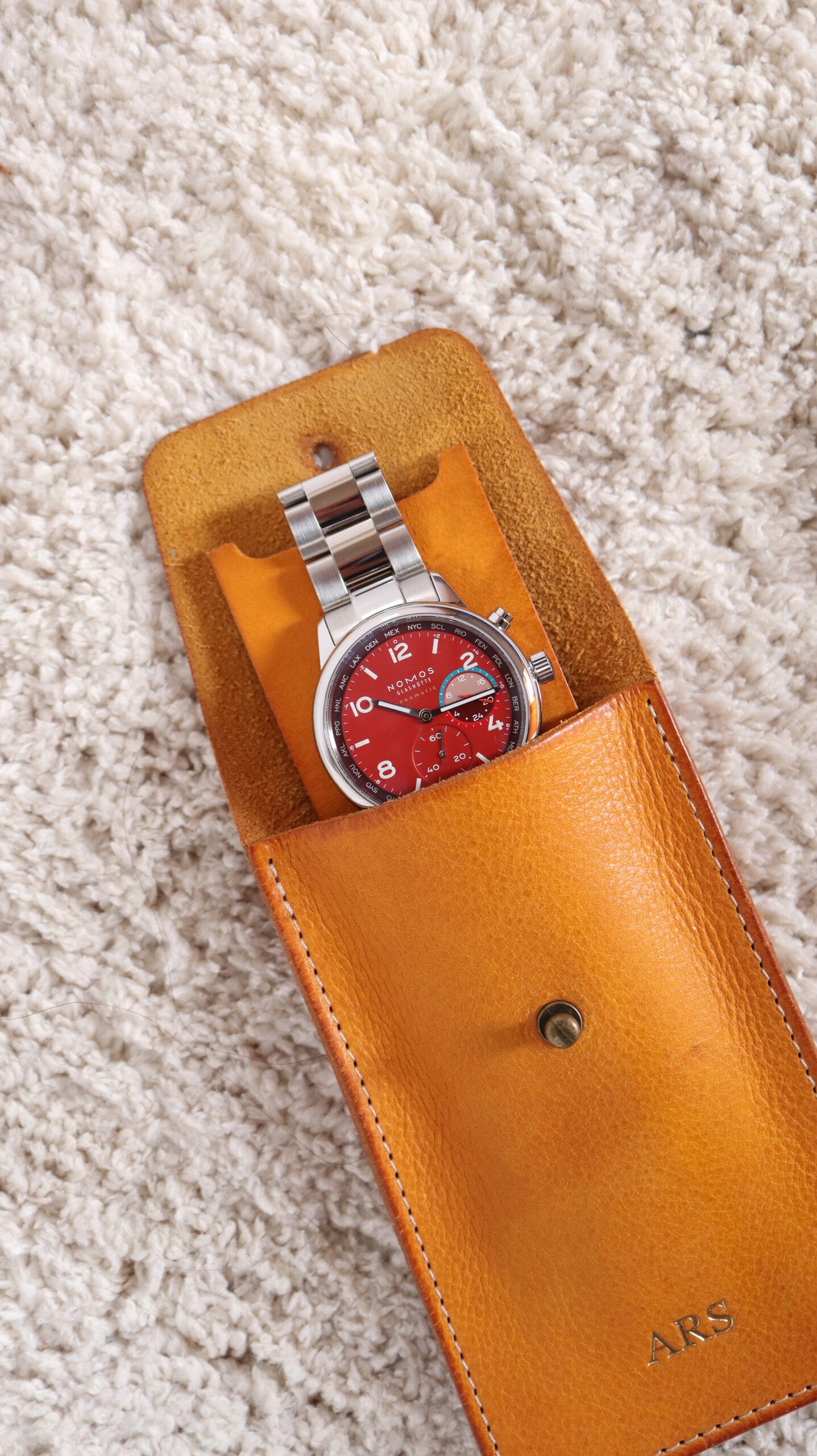 Reloj Nomos Club Worldtimer Magma en estuche de piel Watchpouch